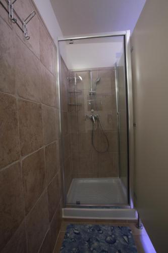 a shower with a glass door in a bathroom at Hostel Adriatic Piran in Piran
