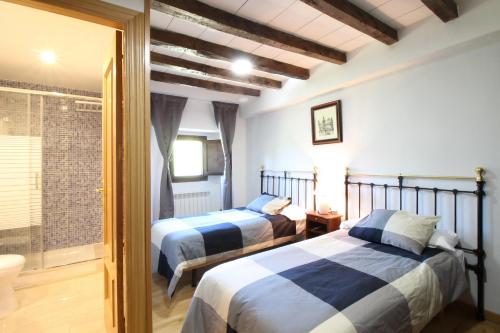 two beds in a room with a window at La Posada Del Santuario in Nava de Santullán