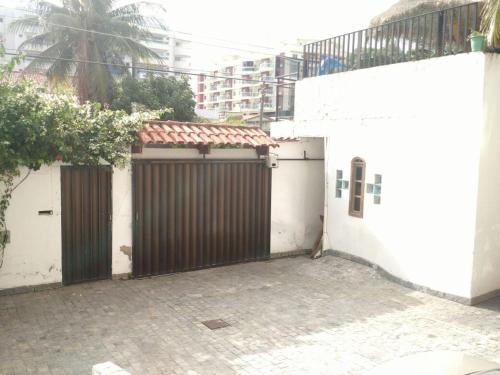 a garage with a gate and a white building at Suítes Tropicana guesthouse in Cabo Frio