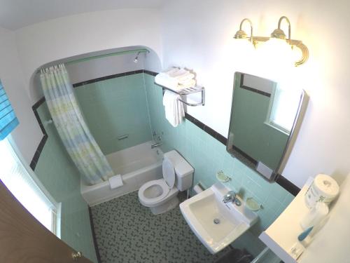a bathroom with a toilet and a sink and a mirror at King Charles Hotel in Ocean City