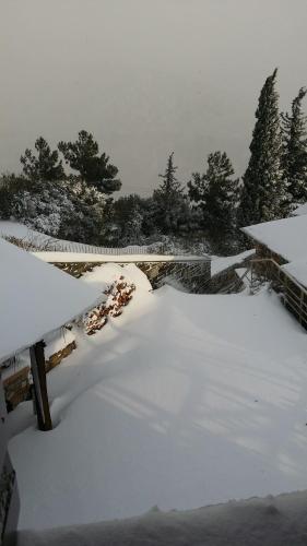a snow covered yard with a bridge and trees at Pacithea Villas in Miléai