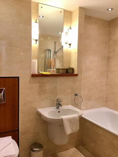 a bathroom with a sink and a tub and a mirror at Edinburgh Old Town in Edinburgh