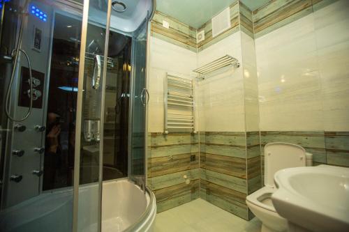 a bathroom with a shower and a toilet and a sink at Ire Palace in Batumi