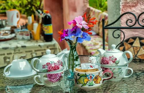 een tafel met een vaas van bloemen en theekopjes bij Nonna Vincenza in Maratea