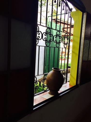 a vase sitting on a window sill next to a fence at Hostal Casa San Miguel in Masaya