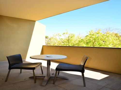 a table and two chairs in a room with a window at Mornington Hotel in Mornington