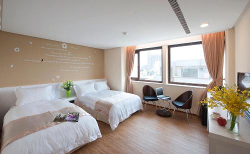 Habitación de hotel con 2 camas y 2 sillas en Hotel Taiwan Changhua, en Changhua City