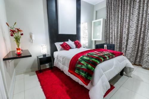 a bedroom with a large bed with a red blanket at Hotel El Rubi in Huaraz