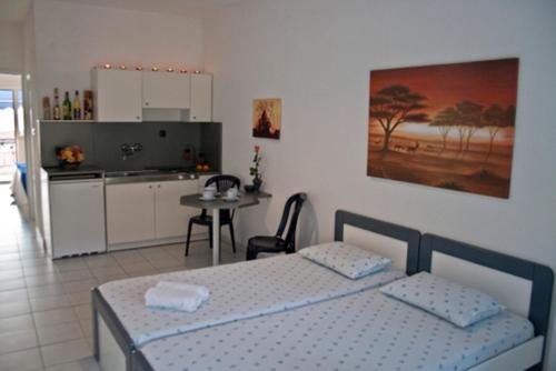Cet appartement comprend une chambre avec un lit et une cuisine avec une table. dans l'établissement Galini Sea View Apartments Chalkidiki, à Nea Skioni