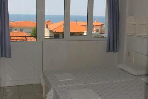 Cette chambre blanche dispose de deux fenêtres et offre une vue sur l'océan. dans l'établissement Galini Sea View Apartments Chalkidiki, à Nea Skioni