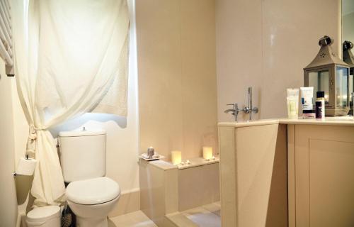 a bathroom with a toilet and a shower with candles at Unique Apartment in the Heart of the City in Rhodes Town