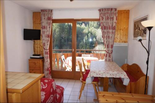 a living room with a table and a window at La Grangette - Morzine in Morzine