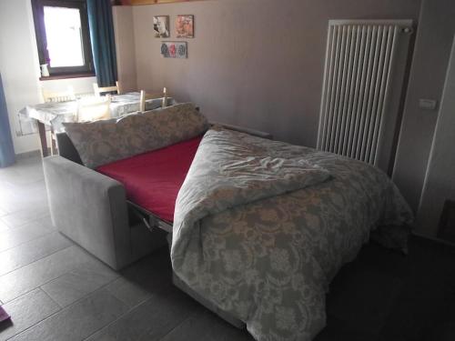 ein Schlafzimmer mit einem Bett und einem Tisch mit einem Fenster in der Unterkunft Maison Pépé et Mémé in Torgnon