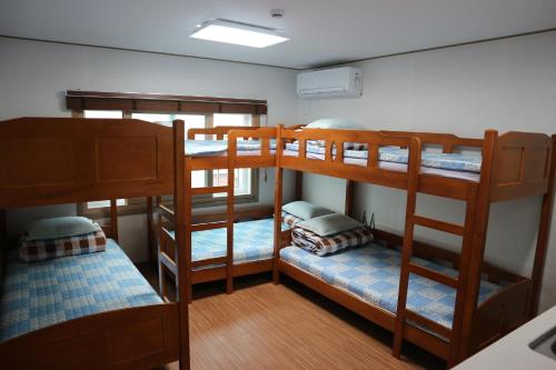 a room with four bunk beds in a room at Blue Island Guesthouse in Seogwipo