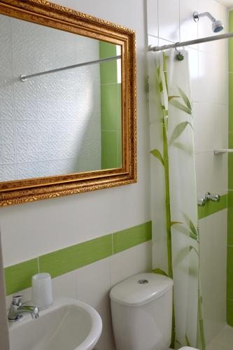 a bathroom with a toilet and a sink and a mirror at Magic Garden House in Cali