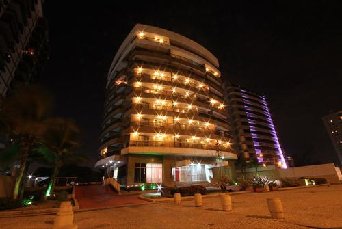 un gran edificio con luces encendidas por la noche en Beach Apartments - GMT, en Río de Janeiro