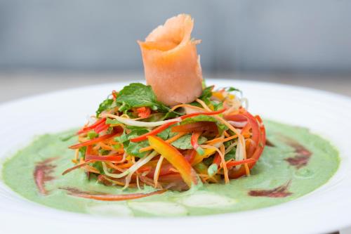 a plate of food with a salad on a plate at The Grandmark Dhaka in Dhaka