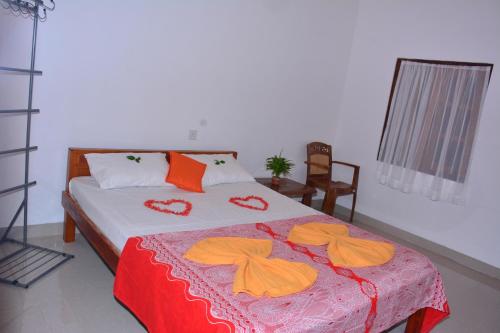 a bedroom with a bed with orange towels on it at Pleasant Park Holiday Inn in Trincomalee
