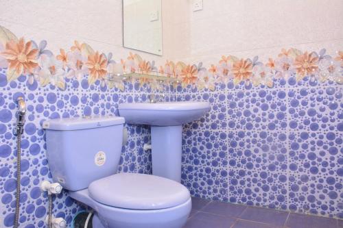ein Badezimmer mit einem blauen WC und einem Waschbecken in der Unterkunft Pleasant Park Holiday Inn in Trincomalee