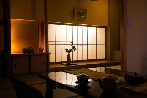 a room with a window with a vase with a plant at Ryokan Seishounagon in Tsu