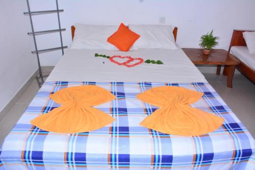 a bed with two orange hats on top of it at Pleasant Park Holiday Inn in Trincomalee