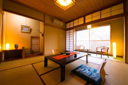 uma sala de estar com uma mesa e uma janela em Ryokan Seishounagon em Tsu
