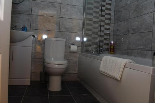 a bathroom with a toilet and a bath tub at The Lodge B&B @ Cannock Chase in Cannock