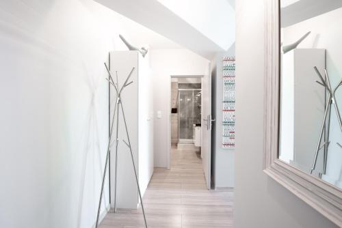 korytarz z białymi ścianami i lustrem w obiekcie Kapitańska Apartament w mieście Gdynia