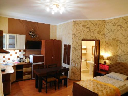 a room with a bed and a kitchen with a table at ApartHotel Dom in Odesa