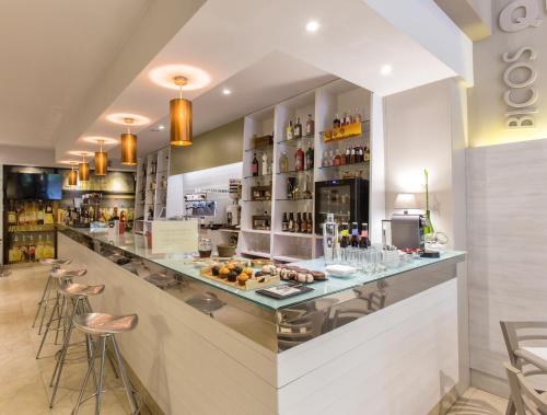 a bar in a restaurant with stools at Hotel Alda San Carlos in Santiago de Compostela