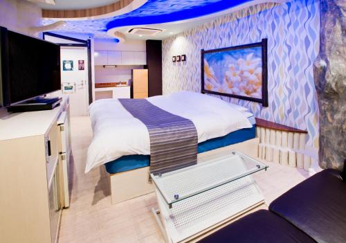 a bedroom with a large bed in a room at ホテルココナッツリゾートアミー Love Hotel in Kagoshima