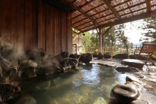 a pool of water with rocks in a building at Yamagataya in Kitakata