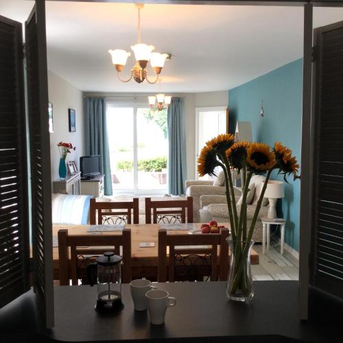 a living room with a vase of flowers on a table at Beachside Apartment in Bangor