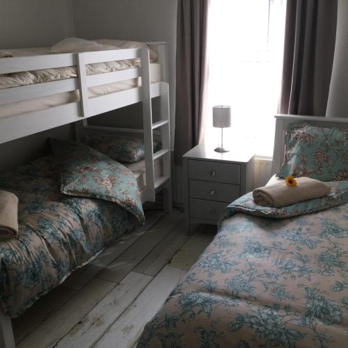 a bedroom with two bunk beds and a bed with a pillow at Beachside Apartment in Bangor