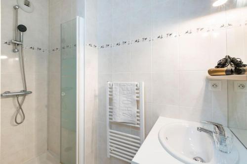 a white bathroom with a sink and a shower at Sweet Apartment in Saint Malo