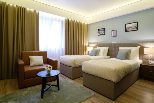 a hotel room with two beds and a couch at SL Industry Hotel in Trebinje