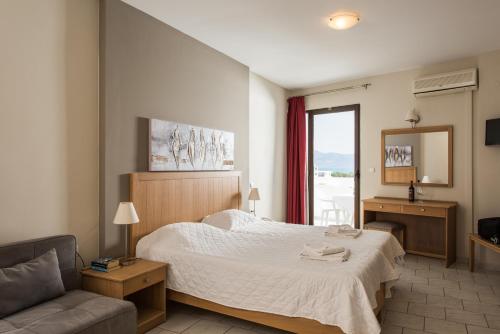 um quarto com uma cama, um sofá e uma janela em Mirtilos Studios & Apartments em Kissamos