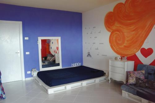カスタニェート・カルドゥッチにあるMonolocale in residence con Piscinaの青い壁のベッドルーム1室(ベッド1台付)