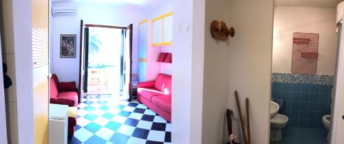 um quarto com duas cadeiras vermelhas e uma casa de banho em Mono Logge em Marciana Marina