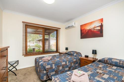 a living room with two beds and a couch at Coranda Lodge in Armadale