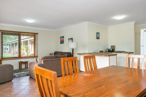 a kitchen and living room with a table and chairs at Coranda Lodge in Armadale
