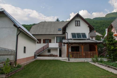 una grande casa bianca con portico e cortile di Apartmaji Mlekuž a Bovec