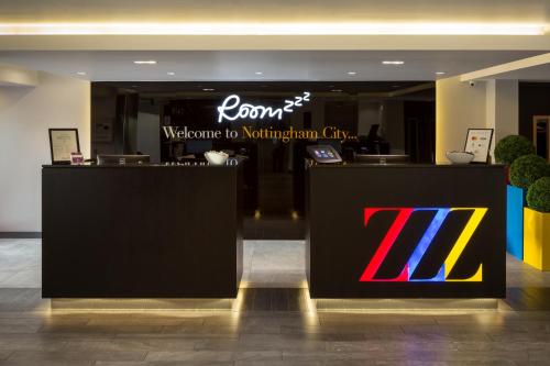 a hotel lobby with a reception desk with a sign at Roomzzz Nottingham City in Nottingham