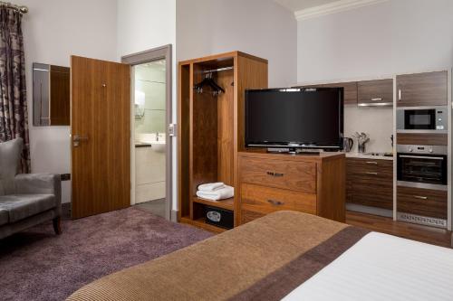 a hotel room with a bed and a flat screen tv at Roomzzz Newcastle City in Newcastle upon Tyne