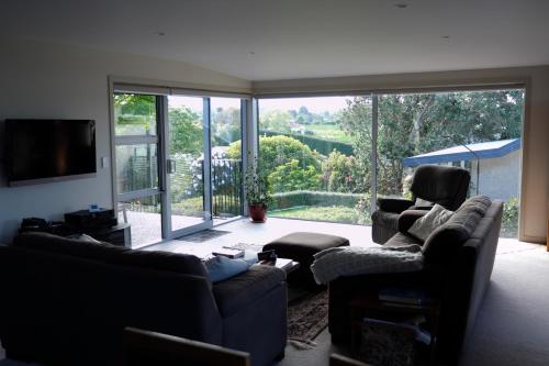 a living room with two couches and a large window at For Puffed Pedallers in Mapua