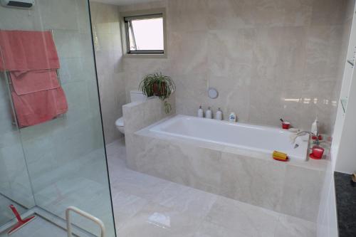a bathroom with a tub and a glass shower at For Puffed Pedallers in Mapua
