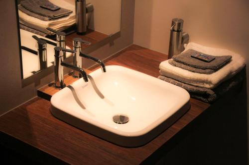 a white sink in a bathroom with towels at De Zevende Zon in Poperinge