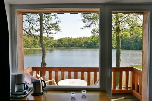 a window with a view of a lake at Seehaus Hartwigsdorf in Klein Vielen