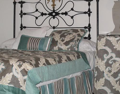 a bedroom with a bed with green and brown pillows at Palacio de la Rambla in Úbeda