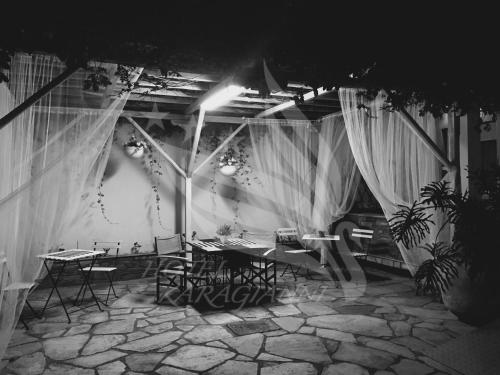 a room with tables and chairs and curtains at Hotel Karagianni in Volos